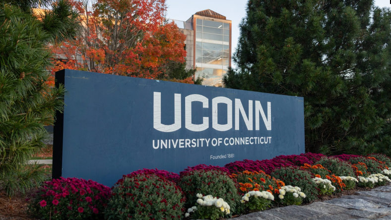 UConn campus sign surrounded by fall foliage near engineering and research buildings.