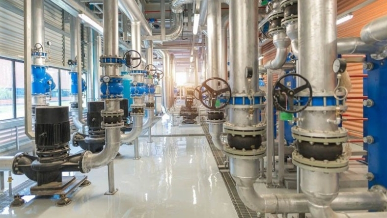 Industrial water pipes and valve systems inside a modern utility facility