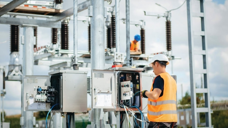 Utility worker inspecting electrical control panels at a water utility facility